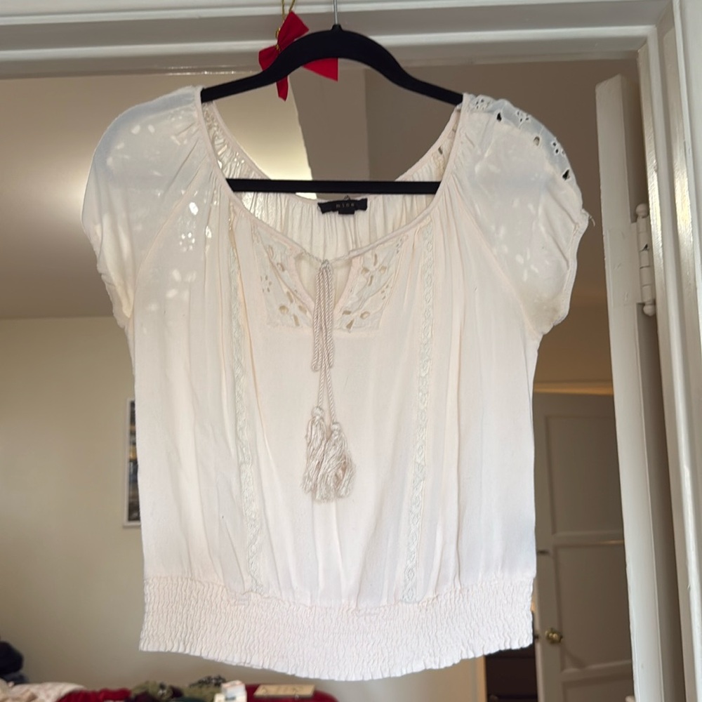Off white top with crochet detailing on cap sleeves and throughout the piece